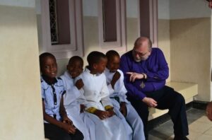 Bishop David Torraville, diocese of Central Newfoundland, spends some time with children before the Sunday church service at St. Alban’s Cathedral, Dar es Salaam. Photo: Andrea Mann